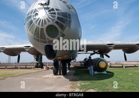 Ein Besucher untersucht die nuklearen Sprengkopf neben der B-36-Bomber am Schloss-Luft-Museum, Merced CA USA Stockfoto