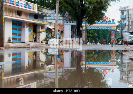 Reflexionen in einer überfluteten Straße am Eingang von der indischen Stadt Puttaparthi Stockfoto