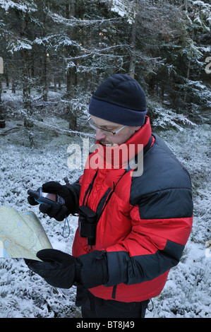 Wanderer, die Überprüfung des Kurs mit einer Karte und einem GPS-Empfänger in der Nähe von Filipstad im Winter, Vaermlands Lan, Schweden Stockfoto