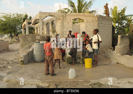 Frauen und Kinder Wasser aus einem Standrohr in Haiti zu sammeln Stockfoto