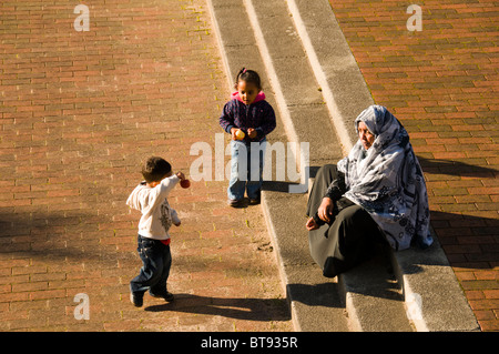 Asiatische Frau mit zwei kleinen Kindern auf der Piazza außerhalb der Lowry Centre bei Salford Quays, Manchester, England, UK. Stockfoto