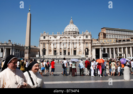 Touristen und katholische Nonnen auf dem Petersplatz, Rom. Stockfoto