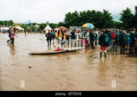 Muddy Massen und ein Kanu in einem See von Schlamm auf dem Glastonbury Festival 1998, würdig, Farm, Pilton, Somerset, England, Vereinigtes Königreich. Stockfoto