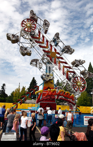 Ein Karneval Fahrt Spins, die seine Fahrer herum wie Kunden sich für Linie dort eigene Reihe an der Spitze Spinnerei Spaß. Stockfoto