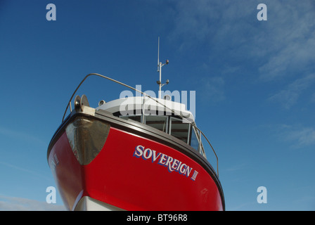 Ein Fischerboot vor einem strahlend blauen Himmel in gemeinsame Hafen, Northumberland, UK Stockfoto