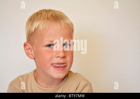 Kleiner Junge seine Zunge stossen Stockfoto