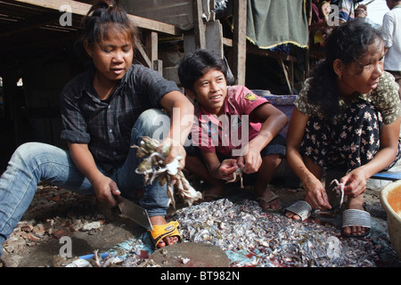 Eine Gruppe von jungen Asiaten sind die Köpfe der Frösche auf einer Straße in ein Hausbesetzer Slum in Phnom Penh, Kambodscha abschneiden. Stockfoto