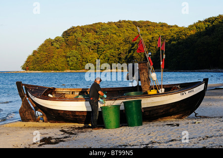 Fischer, die Reinigung seiner Netze im Abendlicht, Ostsee resort Binz, Insel Rügen, Mecklenburg-Vorpommern Stockfoto