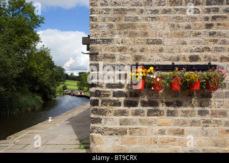 Blumen im Feuer Eimer bei Cafe Cargo am Leeds-Liverpool-Kanal in Foulridge, Lancashire Stockfoto