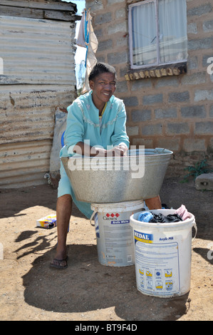 Frauen, die Wäsche in einer Zinn Wanne vor dem Haus, Slum, Township, Queenstown, Eastern Cape, Südafrika, Afrika Stockfoto