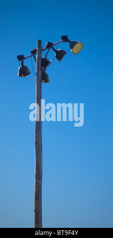 Eine ältere Holzstange Lichter in ein Baseball Feld Beleuchtungssystem an einem strahlend blauen Himmel-Tag. Stockfoto