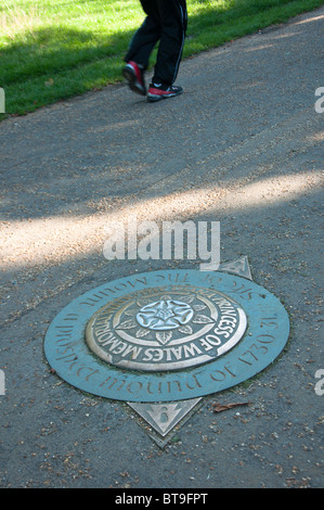 Ein Jogger im Hyde Park führt vorbei an einer Prinzessin Diana Memorial Walk-Plakette Stockfoto