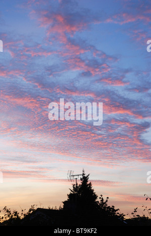 Sonnenuntergang und Cirrus-Wolken über Dächer in Anglesey, Nordwales Stockfoto