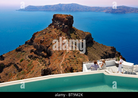 Touristen auf der Terrasse des Hotels mit Blick auf die vulkanische Plug von Imerovigli, Santorini, Griechenland. Stockfoto