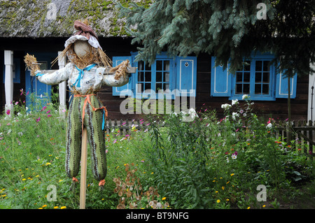 Vogelscheuche vor sehr alte Holzhütte Hexe Strohdach Stockfoto
