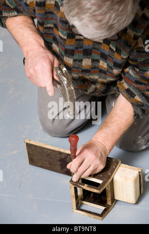 Mann, der einen hölzernes Spielzeug-LKW. Stockfoto