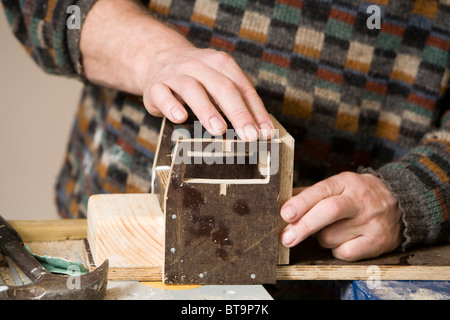 Mann, der einen hölzernes Spielzeug-LKW. Stockfoto