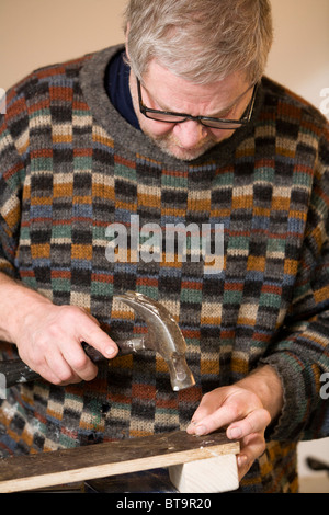 Mann, der einen hölzernes Spielzeug-LKW. Stockfoto