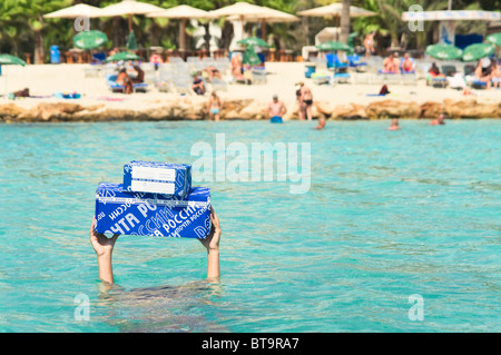 Blaue Briefkästen Russlands in den Händen eines Mannes ertrinken im Meer. Mann unter Wasser, Pakete auf ausgestreckten Armen Stockfoto