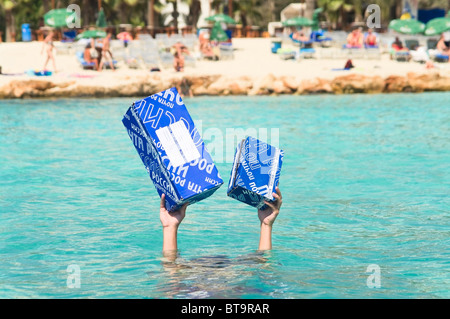 Blaue Briefkästen Russlands in den Händen eines Mannes ertrinken im Meer. Mann unter Wasser, Pakete auf ausgestreckten Armen Stockfoto