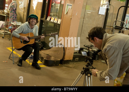 Ein Straßenmusikant hamming es für eine Videokamera auf dem St. Lawrence Market in Toronto. Stockfoto