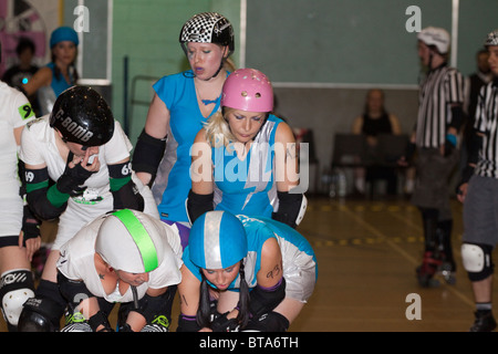 London Roller Girls Line up für die nächste jam in einem Intra-Liga Kampf zwei Skater tief ducken. Stockfoto