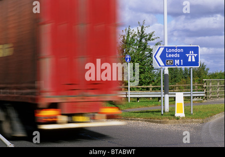 Articulted LKW vorbei Schild mit Beginn der Autobahn M1 in der Nähe von Leeds Yorkshire UK Stockfoto