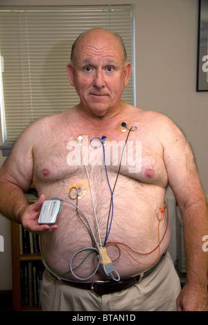 Amerikanische Mann trägt einen Holter-Monitor zur Überwachung der Herz für Herzrhythmusstörungen eingesetzt. HERR Stockfoto