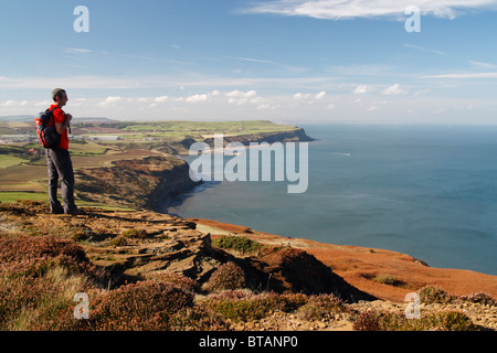 Männliche Wanderer mit Blick auf alte Alaun Steinbrüche zwischen Skinningrove und Staithes auf The Cleveland Art National trail Stockfoto