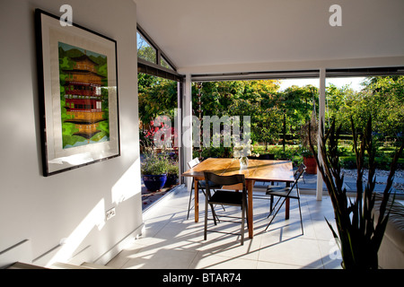 Ein Esszimmer mit Türen, die auf eine Terrasse und Garten öffnen Stockfoto