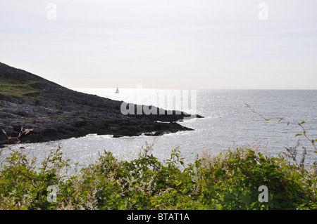 Segelboot auf dem Meer vor der Küste in Gower, Wales Stockfoto