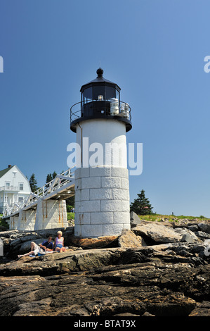 Vertikale Weitwinkelaufnahme des Marshall Point Leuchtturm und Museum mit paar Sonnenbaden auf Felsen. Port Clyde, St. George, Maine Stockfoto