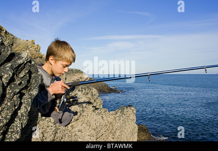 ein kleiner Junge aus dem Felsen auf der Heiligen Insel, Angelsey Angeln. North wales Stockfoto