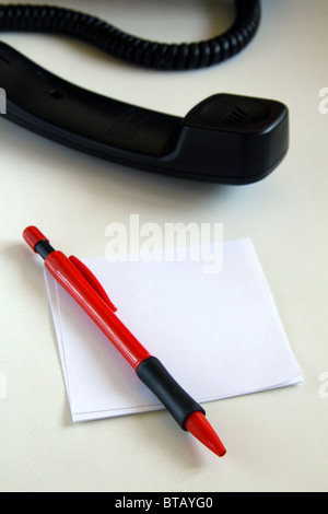 Hörer und einen roten Stift auf das Papier auf einem weißen Tisch Stockfoto