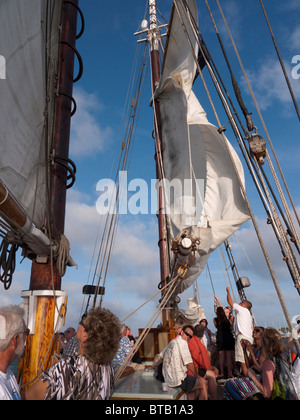 Passagiere, die dazu beitragen, das Segel auf die Segel hissen Schiff der Appledore Schooner aus Key West in Florida USA Stockfoto