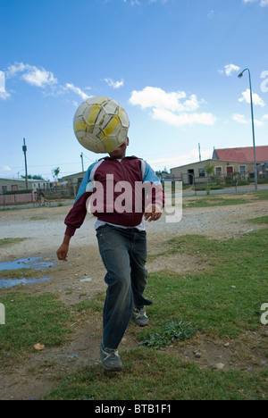 Ein Junge spielt Fußball in Zola Township in Somerset West in der Nähe von Cape Town, Südafrika. Stockfoto