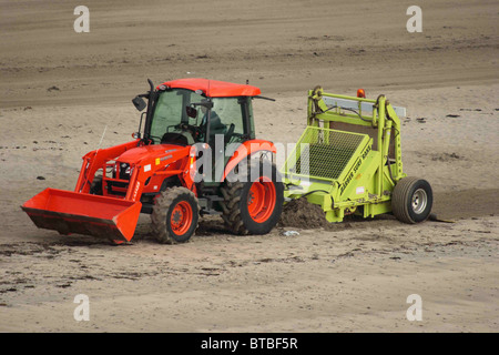 Mechanische Strandreinigung, Looe, Cornwall, September. Strandline Rechen. Stockfoto