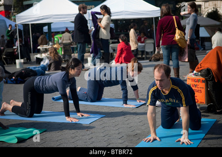 Yoga-Praktizierende aller Niveaus zu beteiligen, in einen kostenlosen Yoga-Kurs in Union Square Park in New York gegeben Stockfoto