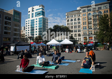 Yoga-Praktizierende aller Niveaus zu beteiligen, in einen kostenlosen Yoga-Kurs in Union Square Park in New York gegeben Stockfoto