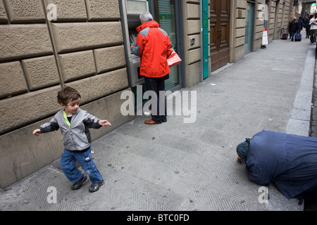 Straße Bettler von jungen italienischen jungen und Bank Kunde Fußgänger auf Florenz Bürgersteig bemerkt. Stockfoto