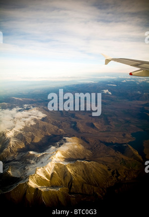 Passagiere Blick auf ein Flugzeug Flügel hoch über den Wolken und Berge Stockfoto