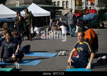 Yoga-Praktizierende aller Niveaus zu beteiligen, in einen kostenlosen Yoga-Kurs in Union Square Park in New York gegeben Stockfoto