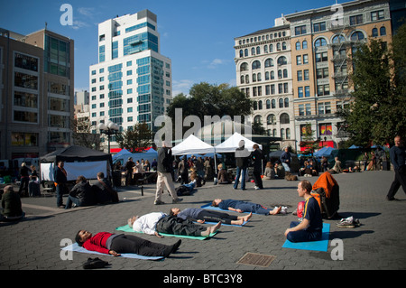 Yoga-Praktizierende aller Niveaus zu beteiligen, in einen kostenlosen Yoga-Kurs in Union Square Park in New York gegeben Stockfoto