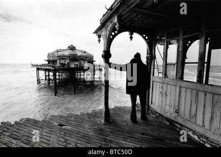 Eine Person steht am Ufer Ende der desolaten West Pier in Brighton Stockfoto