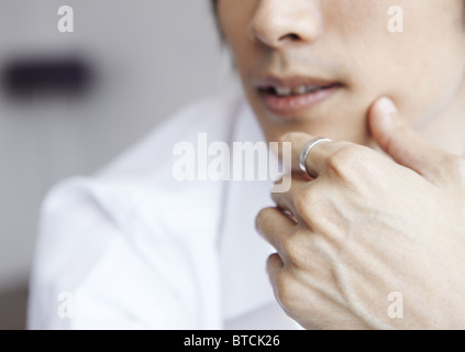 Nahaufnahme von mans Mund und Hand mit einem Ring Stockfoto
