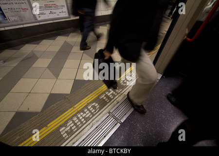 Passagier betreten London u-Bahn im Rohr-Netzwerk mit dagegen die Lücke Zeichen auf Plattform Stockfoto