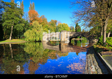 Brücke über den See mit Booten in Thompson Park, Burnley, Lancashire, England, UK. Stockfoto