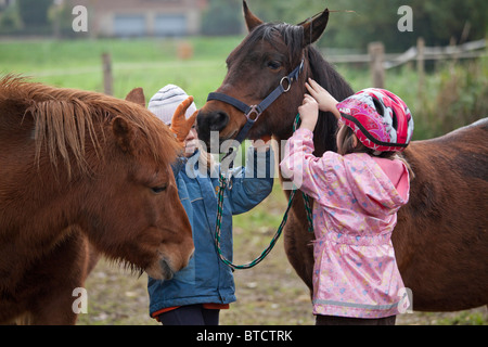 Porträt von zwei kleinen Mädchen ein Pony haltering Stockfoto