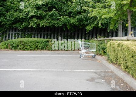 Einzigen Einkaufswagen auf einem leeren Parkplatz. Stockfoto