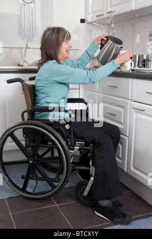 behinderte Frau im Rollstuhl, die Zubereitung von Speisen in der Küche Stockfoto